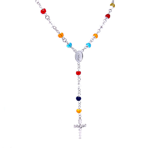 The Rosary Multicolor Crystal Beads Necklace White Gold filled features vibrant crystal beads in red, blue, and orange shades. It includes a silver medallion at the center and finishes with a crucifix at the base. The beads are beautifully connected by metal links, all set against a sleek white background.